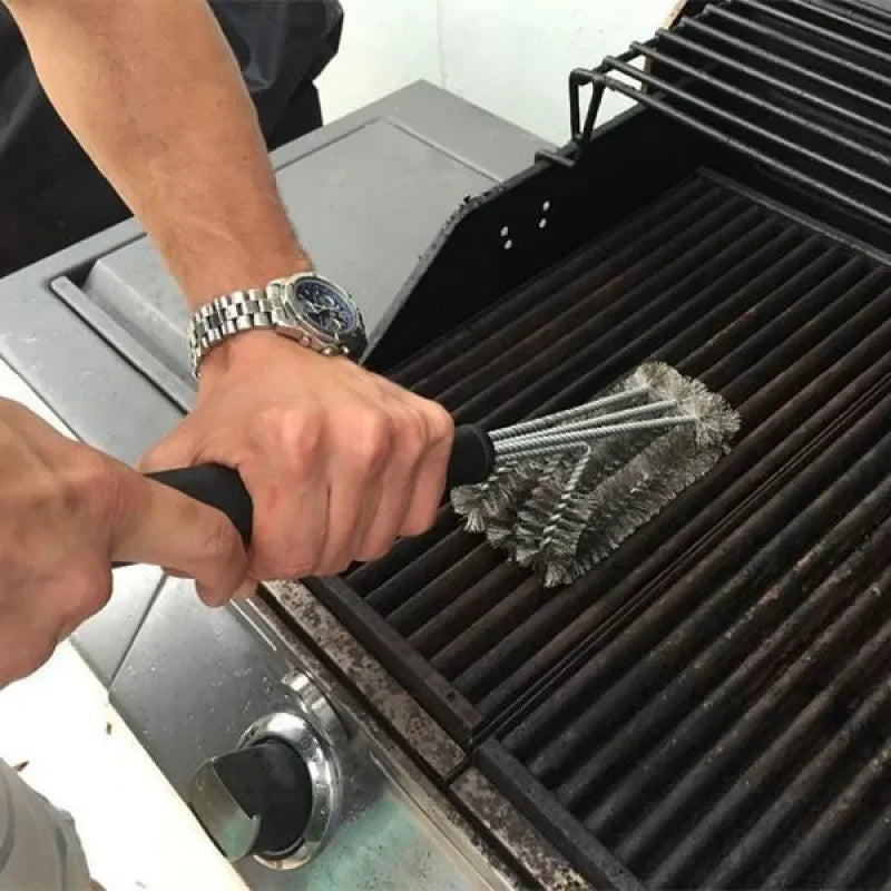 Person cleaning barbecue grill grates with wire bristle brush, outdoor BBQ tool